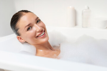 Relaxation and bathing concept. Portrait of happy European woman taking foamy bath, smiling at...