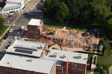 Old building demolition site. Construction excavator tearing down obsolete brick walls. City...