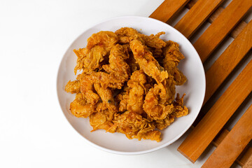 Crispy shrimp served on a plate with a wooden coaster