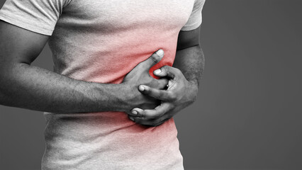 Food poisoning. Cropped of black man with abdominal pain, suffering from diarrhea, photo with red...