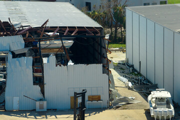 Warehouse with motorboats and yachts destroyed by hurricane winds in Florida coastal area. Natural...