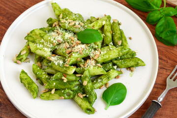 Pasta penne with fresh basil pesto, grated cheese and sunflower seeds
