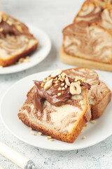A piece of marble biscuit with chocolate cream and nuts