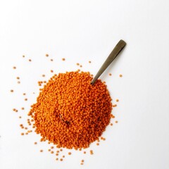 Raw, unprocessed, organic red lentils with a spoon on a white background