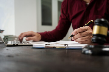 A male lawyer is working at his desk on an online judicial review, focusing on justice, fairness, and legal compliance.He reviews cases, contracts, and legal matters based on general law principles