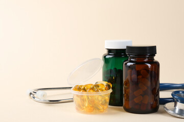 Pharmacist. Many pills in plastic container, bottles and stethoscope on beige background