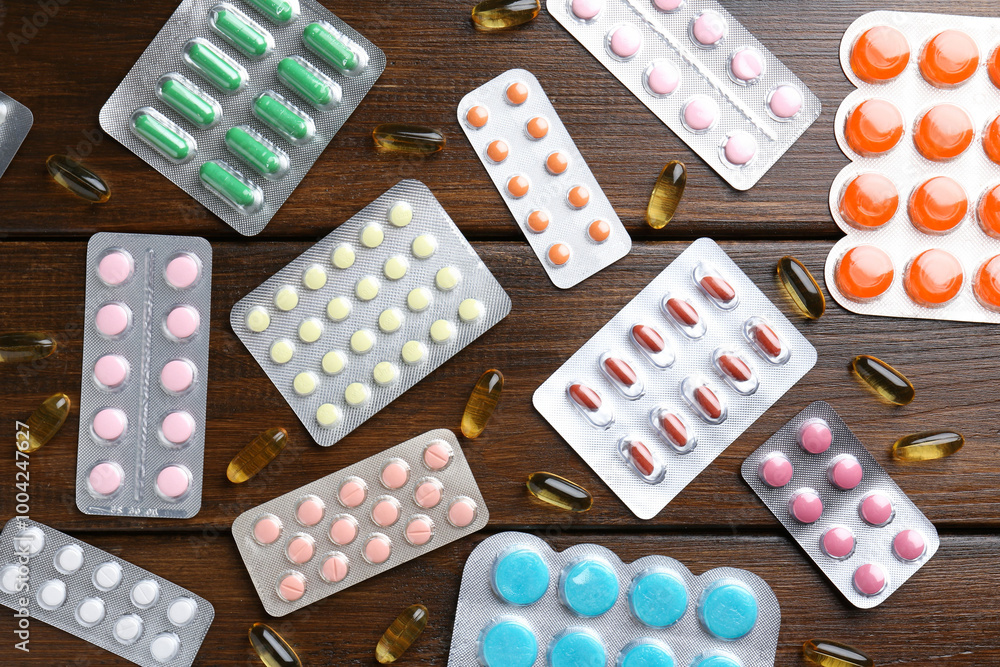 Poster Pharmacist. Different pills on wooden table, flat lay