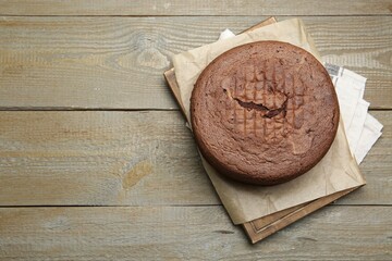 Tasty chocolate sponge cake on wooden table, top view. Space for text