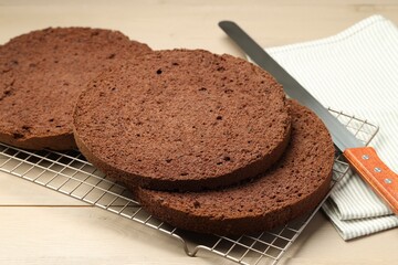 Cut tasty chocolate sponge cake and knife on wooden table, closeup