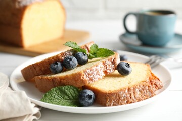 Freshly baked sponge cake, mint and blueberries on white wooden table, closeup