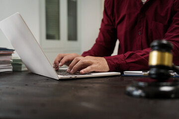 A male lawyer is working at his desk on an online judicial review, focusing on justice, fairness, and legal compliance.He reviews cases, contracts, and legal matters based on general law principles