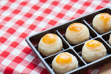 Delicious Chinese pastry moon cake puffs arranged on Package plastic box. Chinese Pastry Bun on tablecloth.