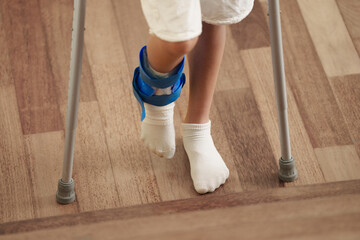 Injured child on crutches. Boy in cast on foot
