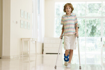 Injured child on crutches. Boy in cast on foot