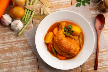 Asian style chicken stew in white plate.Slow cooked chicken,a rich and hearty mix of tender chicken and crispy skin smothered in gravy-like sauce.Top view.