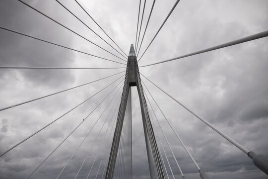 Detail of suspension bridge with cloudy sky