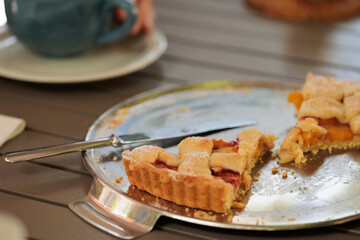 vista dettagliata da vicino di alcune fette di una crostata dolce, con albicocche, fatta in casa, su un vassoio di metallo, di giorno, su un tavolo, a colazione