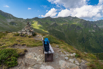 peaceful panoramic view over stony and rocky mountain with alpine meadows and gravel fields, recreational hikers path way through pasture and boulders up to the summit, holiday destination