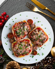 Ham and mini pizzas with mushrooms. Top view table with Christmas decoration.