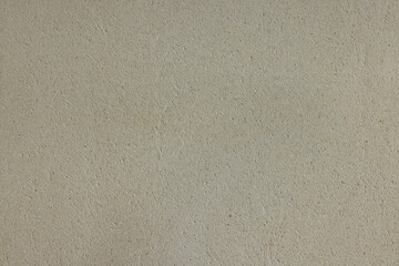 Natural rough beige texture background with a barely visible relief. Empty light cream or beige coloured textured background.