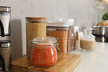 Different types of cereals and legumes in containers on light table