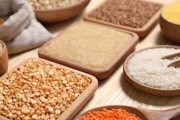Different types of cereals and legumes on table, closeup