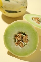 Fresh ripe honeydew melons on beige background, closeup