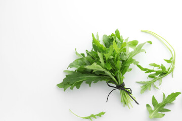 Fresh green arugula leaves on white background, flat lay. Space for text