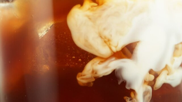 Super Slow Motion of Pouring Milk Into Ice Coffee Drink, Close-up. Filmed on High Speed Cinema Camera, 1000 fps.