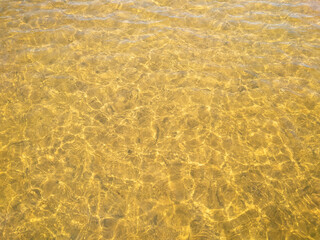 Abstract background. Golden river water surface with sun reflections