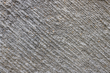Grey-brown concrete surface with diagonal relief. Pattern with diagonal stripes. Point embeddings...
