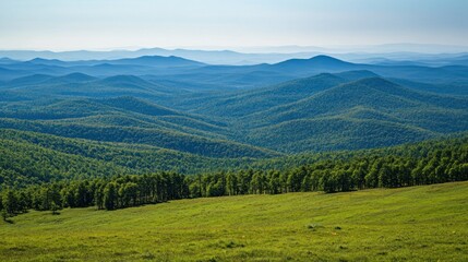Obraz premium A serene landscape showcasing rolling hills and lush greenery under a clear blue sky.