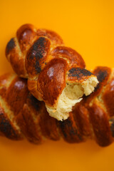 Appetizing yeast roll in a crack. Two fresh homemade challah bread on a yellow background