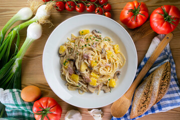 Spaghetti with pineapple, ham and cream sauce. Top view table with  decoration.