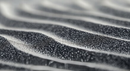 Abstract patterns of black and white sand at a beach during sunrise