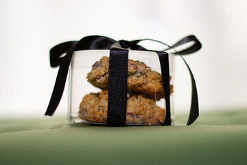 Close up of cookies packaged in a clear plastic case with a black ribon.