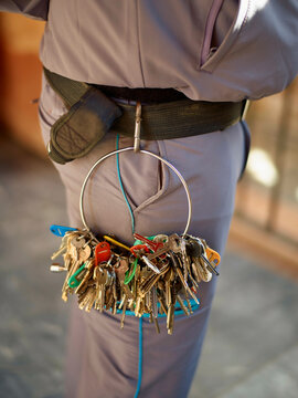 Janitor carrying a large key ring full of various keys.