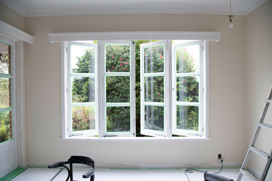 Freshly painted room interior with an open window, a ladder, and renovation tools, Auckland, New Zealand