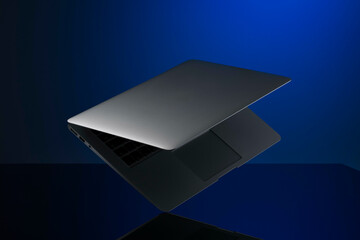 Floating silver laptop with a sleek design against a blue gradient background.