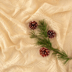 Creative decorative Christmas background made of crochet tablecloth and pine cones and fir branch. Winter Holiday home inspiration.
