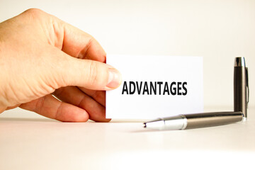 Advantages symbol. Concept word Advantages on beautiful white card. Beautiful wooden background. Businessman hand. Beautiful black pen. Business advantages concept. Copy space.