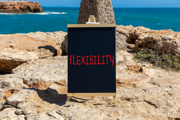 Flexibility symbol. Concept word Flexibility on beautiful chalk blackboard. Beautiful red stone and...