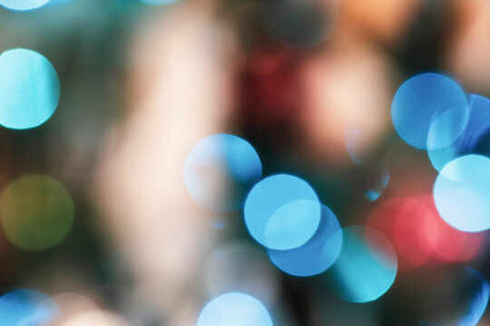 Blue and gold Christmas garland  bokeh lights on a tree, abstract multi colored blurred background.