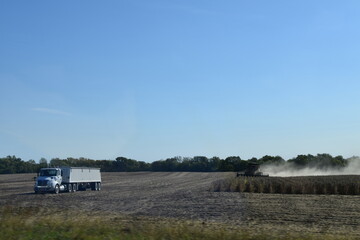 Semi Truck and Combine in a Cultivated Farm Field