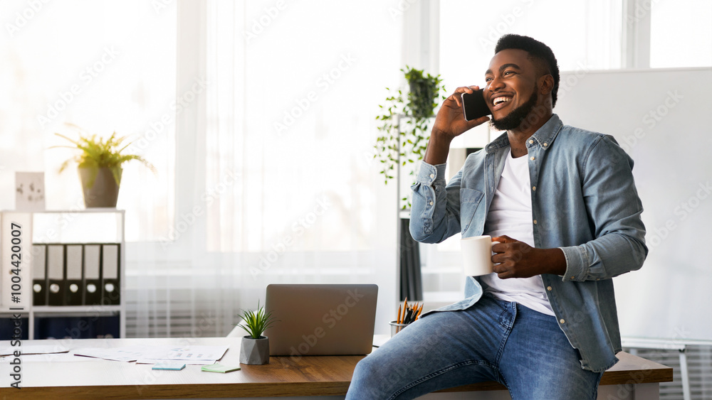 Aufkleber making business is easy. cheerful black businessman talking on smartphone and drinking coffee while 