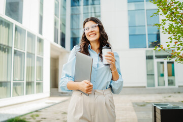 Young successful woman is going to work at modern business building	