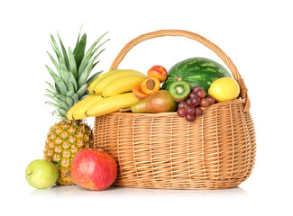 Many different fresh fruits in wicker basket isolated on white