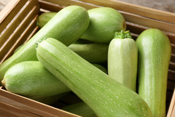 Fresh ripe zucchinis in wooden crate, closeup