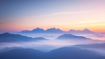 Obraz premium Misty mountains glow softly in the sunset, a landscape of timeless beauty and serene atmosphere.