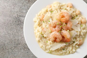 Delicious risotto with shrimps and cheese on grey table, top view